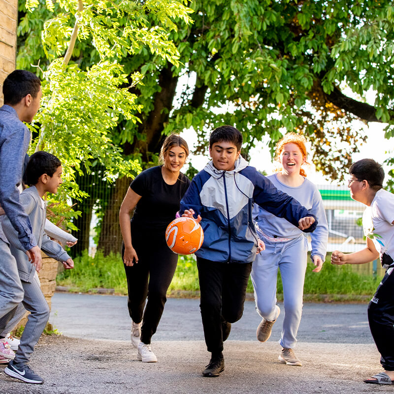 A group of children play with a football